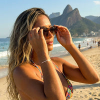 Thumbnail for Woman on a beach in sunglasses wearing the rose gold Crystal Bar Bracelet