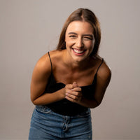 Thumbnail for Smiling woman in casual outfit radiating joy and happiness against a neutral background.