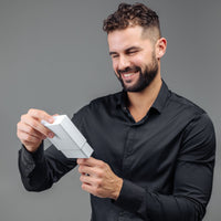 Thumbnail for Man smiling while opening a gift box, showcasing excitement for the Classic Photo Bracelet by Brother & Sisters.