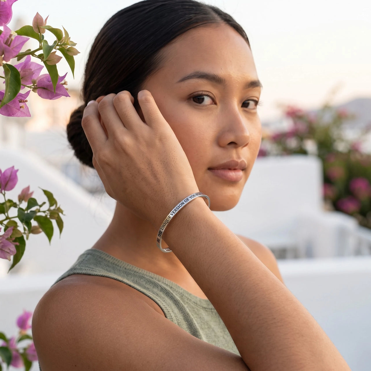Woman gently touching her Be The Unique Version Of Yourself bracelet in silver | SKU: btuvoy-wg